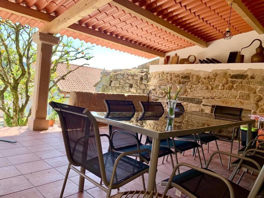 een tafel en stoelen op een patio met een stenen muur bij casa gerente in Muros