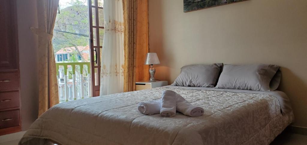 een bed met een handdoek en een raam bij Departamento Don Tuquito in Loja