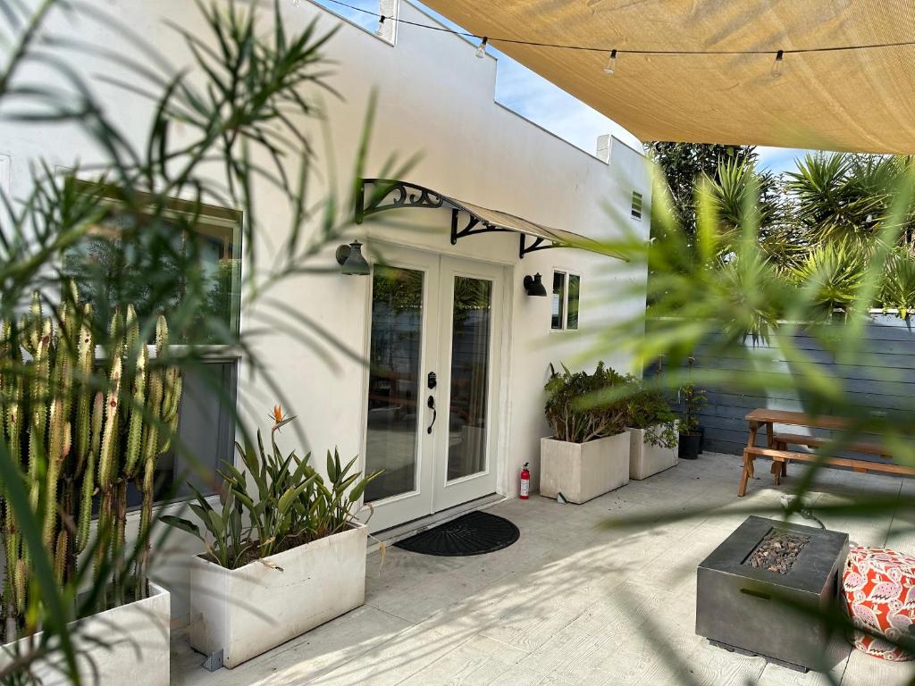 Resort Getaway in Private Garden Terrace Villa w Luxury Amenities في لوس أنجلوس: منزل به نباتات الفخار أمام الباب