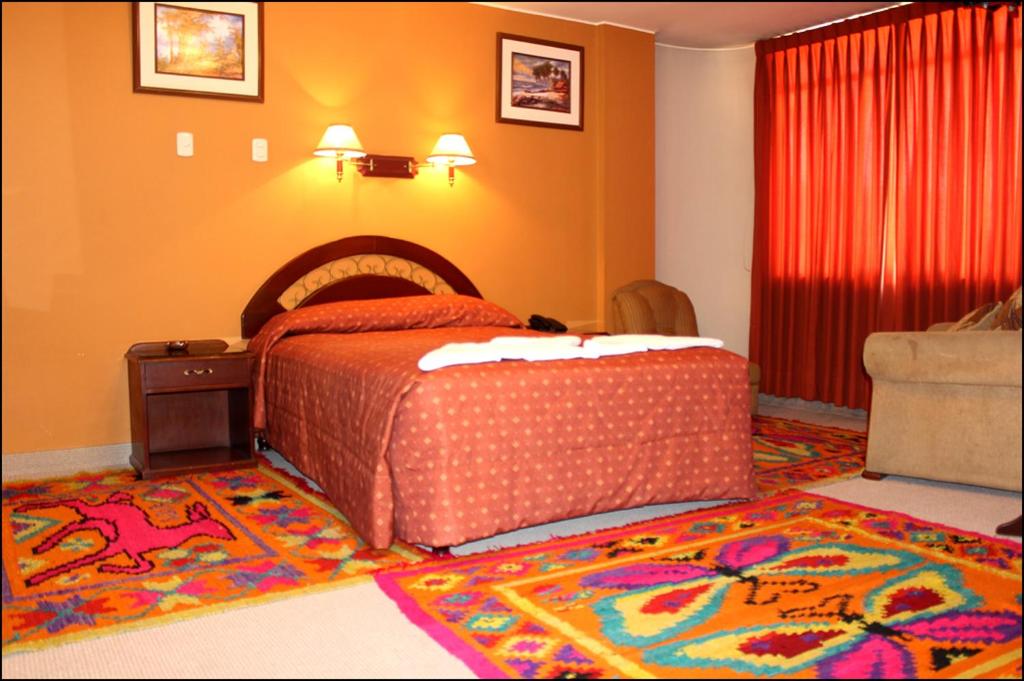 1 dormitorio con cama y alfombra en el suelo en Gran Hotel Alturas, en Huaraz