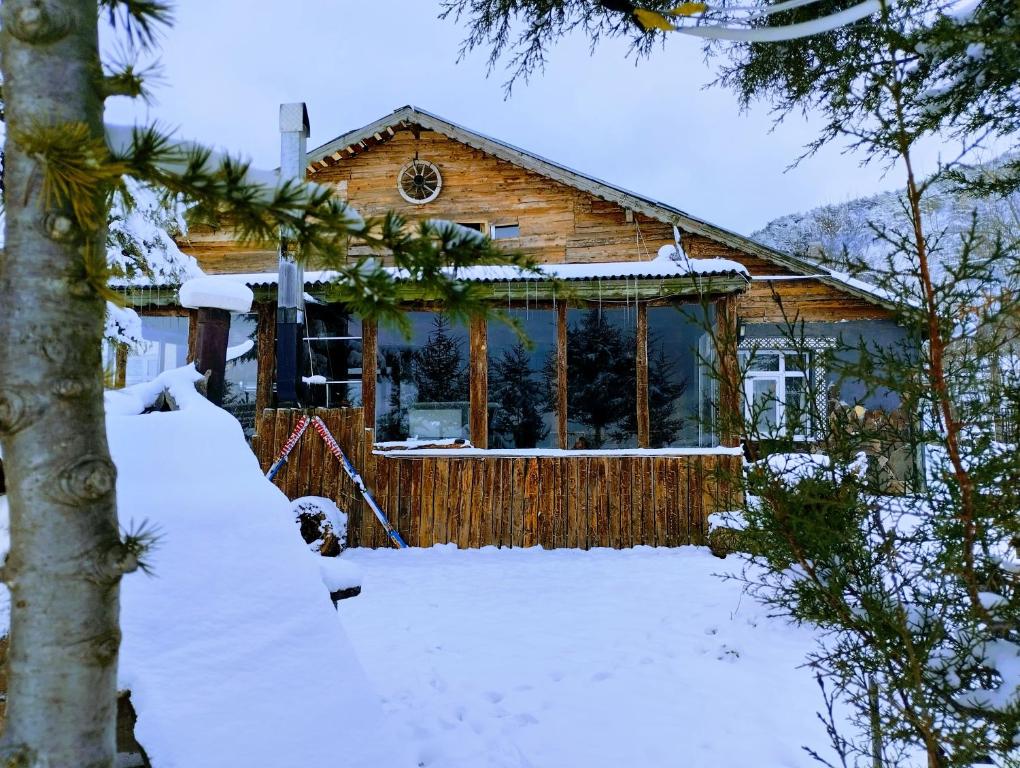 a log cabin in the snow with snow covered trees at İpekyolu dağ evleri in Mudurnu