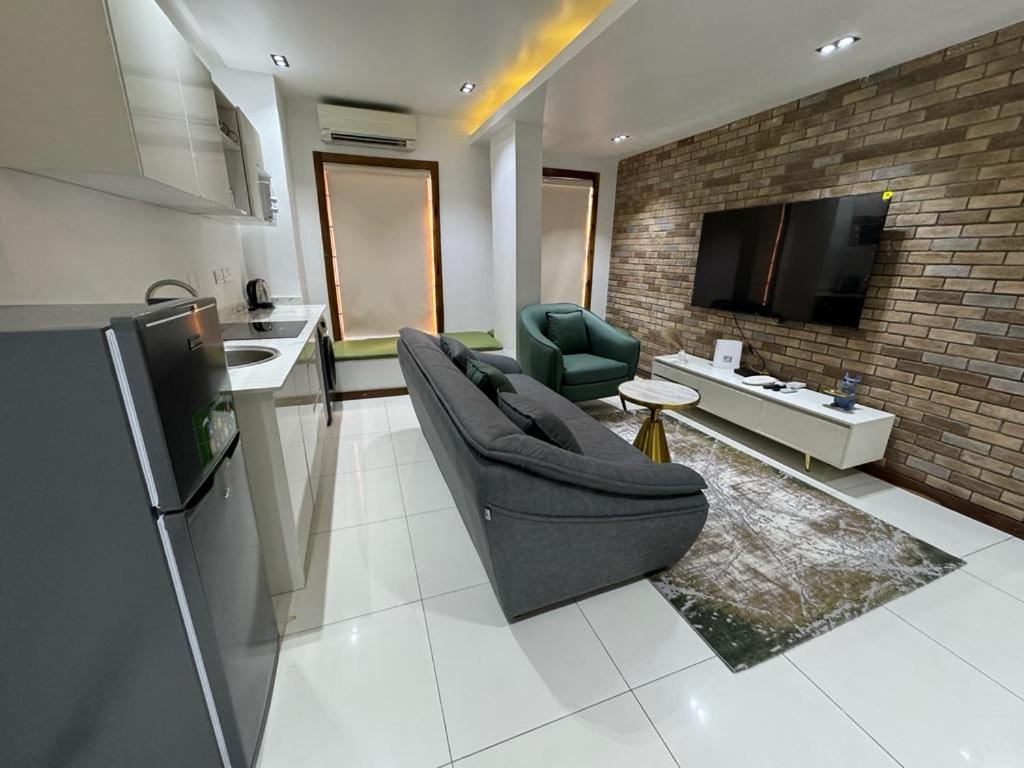 un soggiorno con divano e TV e una cucina di Zara 2 a Lekki