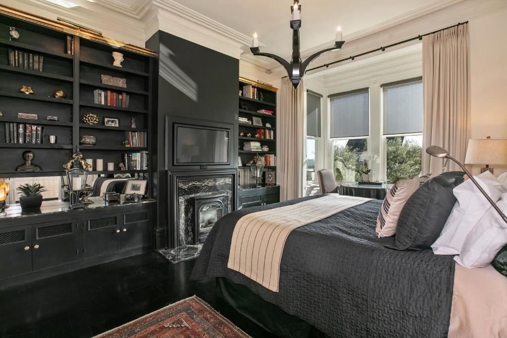 a bedroom with a bed and a fireplace and bookshelves at Pacific Heights Chic Jr Studio in San Francisco