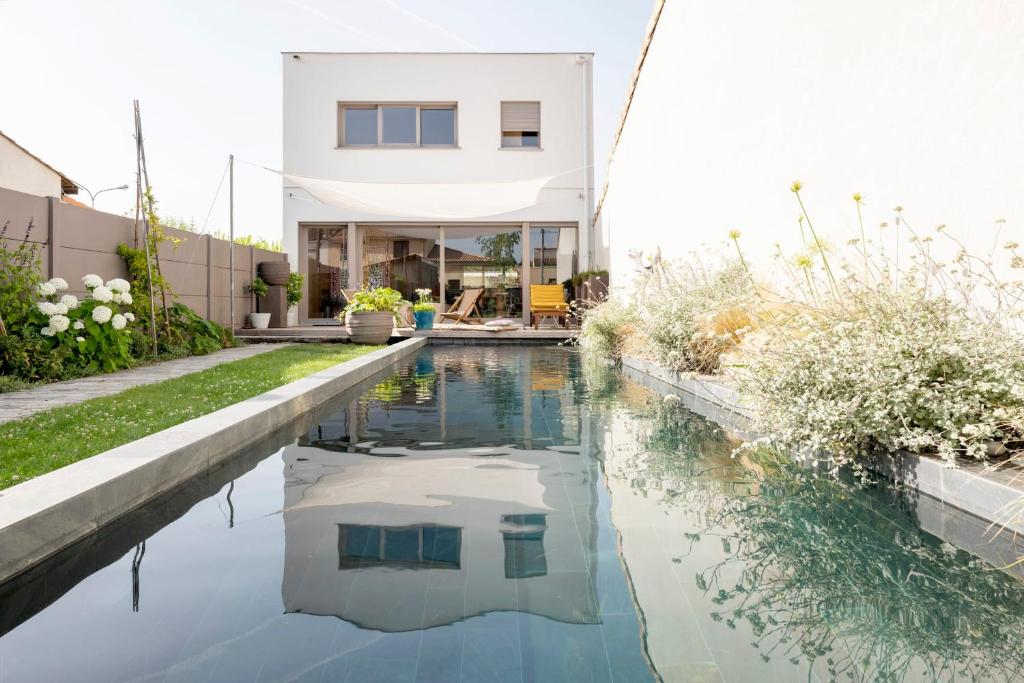 uma casa com piscina em frente a uma casa em Splendid townhouse with private pool em Le Bouscat