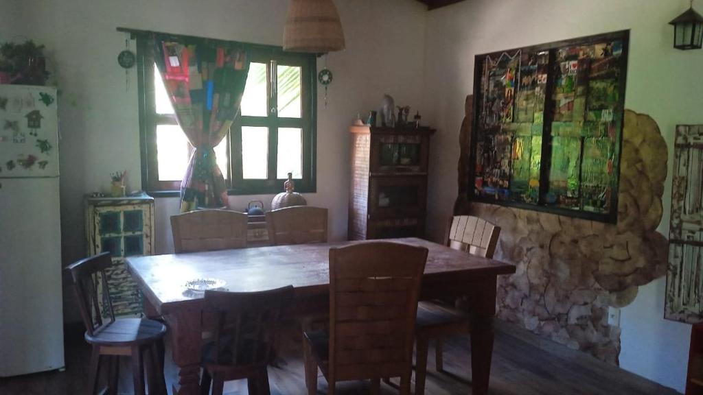 a dining room with a wooden table and chairs at Loft Jardim Imbassai in Imbassai