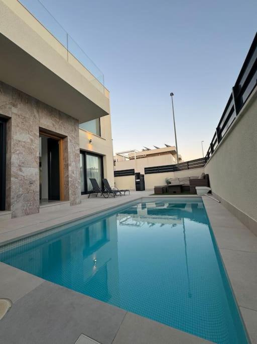 una piscina di fronte a un edificio di Villa Moderna con Piscina a Daya Vieja