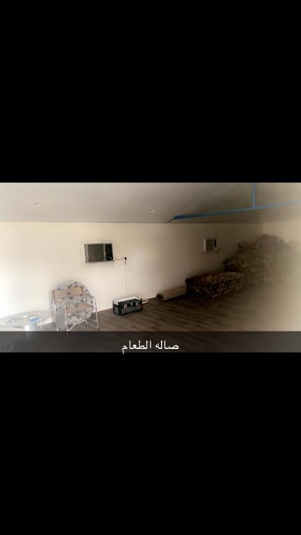 a room with a table and a chair and a television at منتجع السرايا السياحي in Al Qā‘id