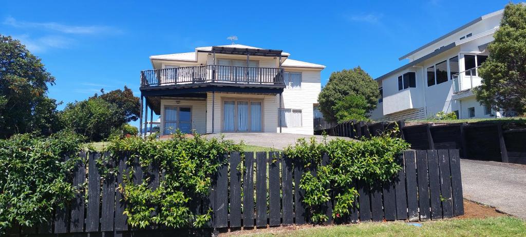 a house with a black fence in front of it at Whitianga Sea Views in Whitianga