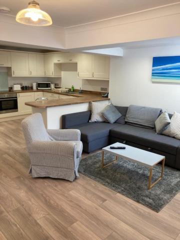 una sala de estar con un sofá y una mesa en Highcliffe Apartment with Parking, en Christchurch