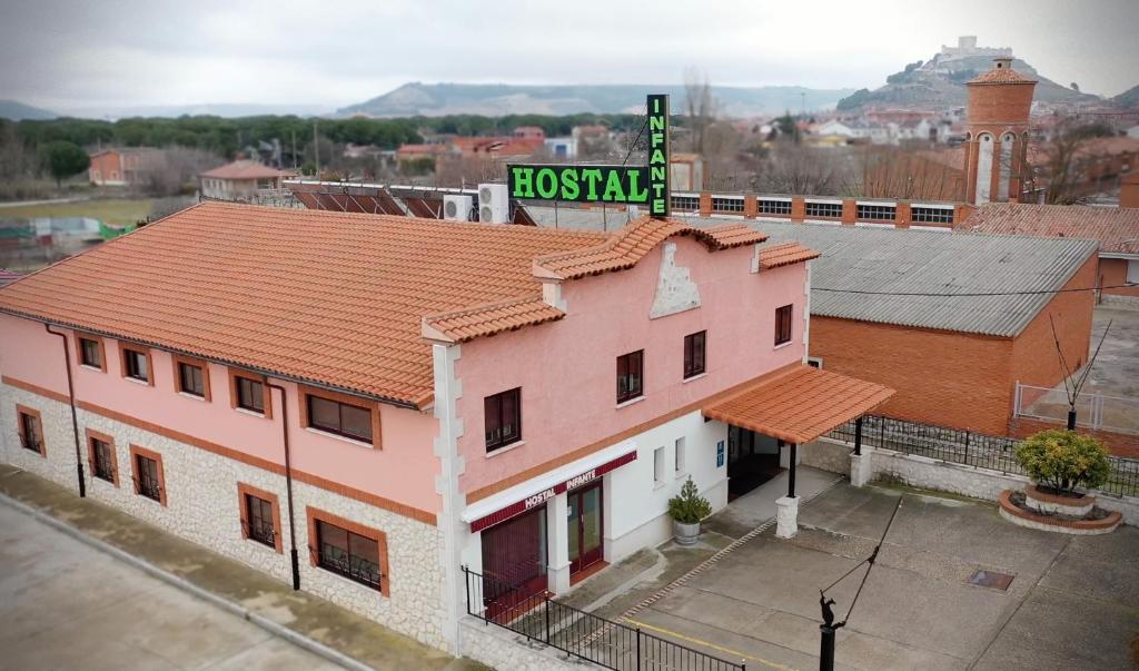 a pink building with a sign on top of it at Hostal Infante Peñafiel in Peñafiel