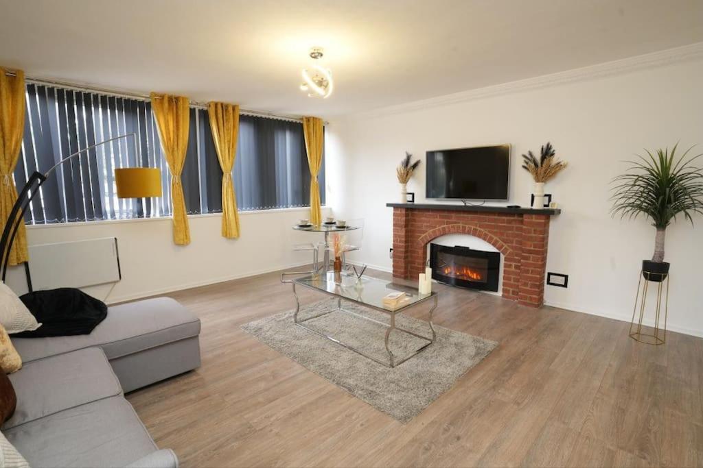 a living room with a couch and a fireplace at Spacious Apartment - Long stays welcome in Luton