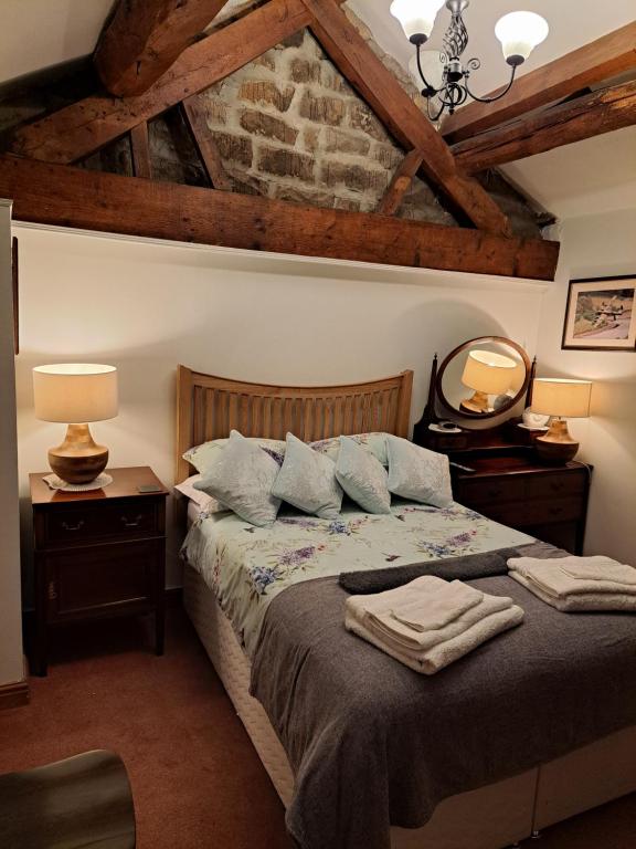 a bedroom with a bed with two lamps and a mirror at Coxleigh House in Chesterfield