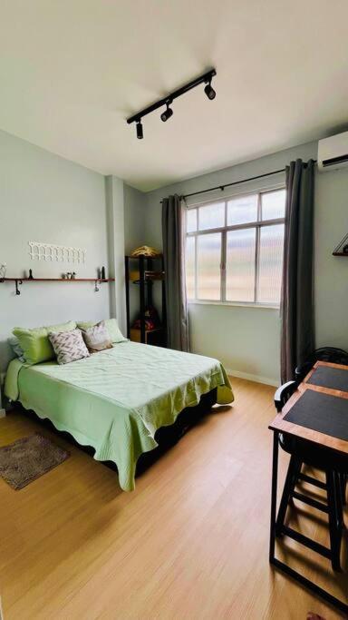 Un dormitorio con una cama verde y una ventana en Estúdio charmoso na Lapa, en Río de Janeiro