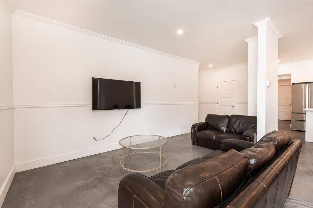 a living room with a couch and a tv on a wall at 3 Bedrooms apartment-1897 in Montréal