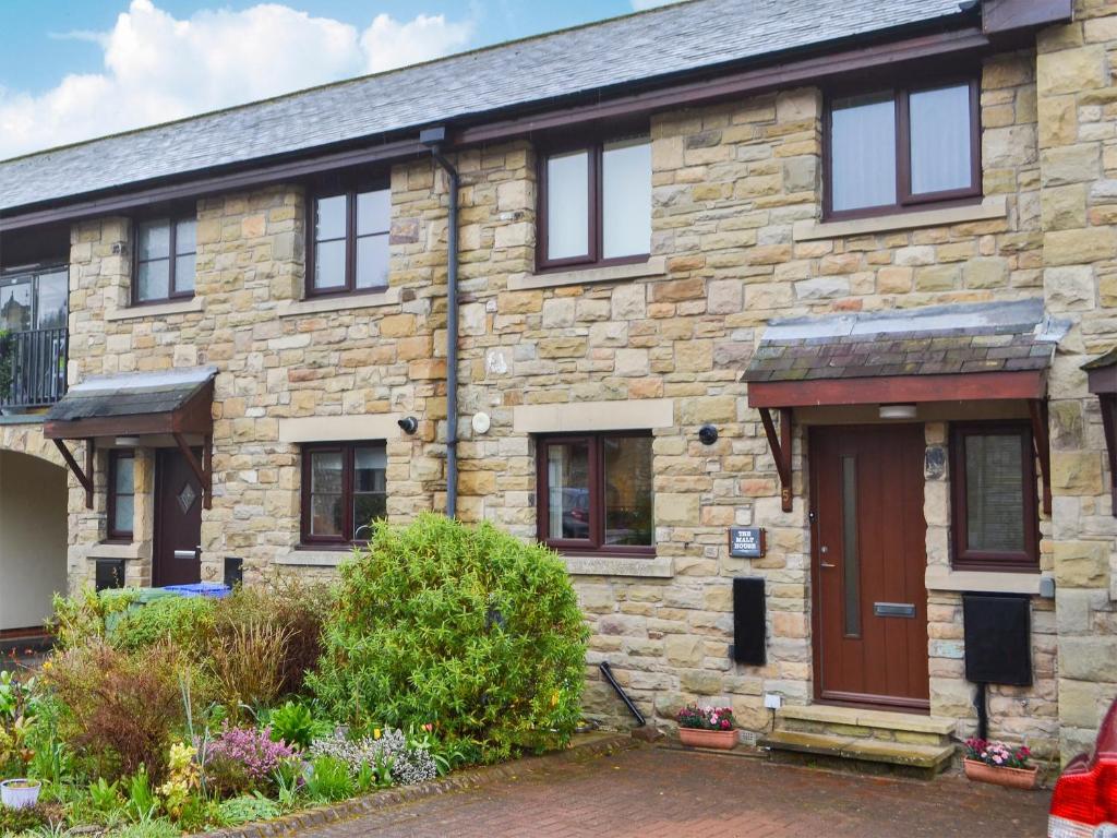 an old stone house with a red door at The Malt House in Rothbury