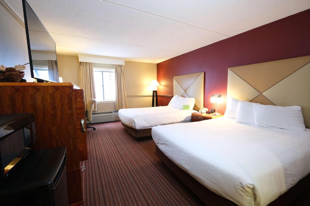 um quarto de hotel com duas camas e uma televisão em Fireside Inn & Suites West Lebanon em West Lebanon