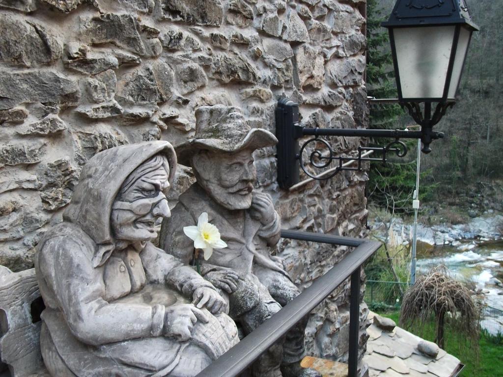 a statue of two people sitting on a rail at La Casetta Vacanze in Molini di Triora