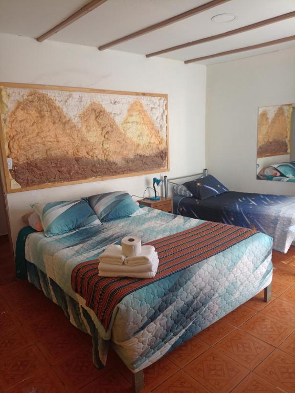 ein Schlafzimmer mit einem Bett mit Handtüchern darauf in der Unterkunft Katchi in San Pedro de Atacama