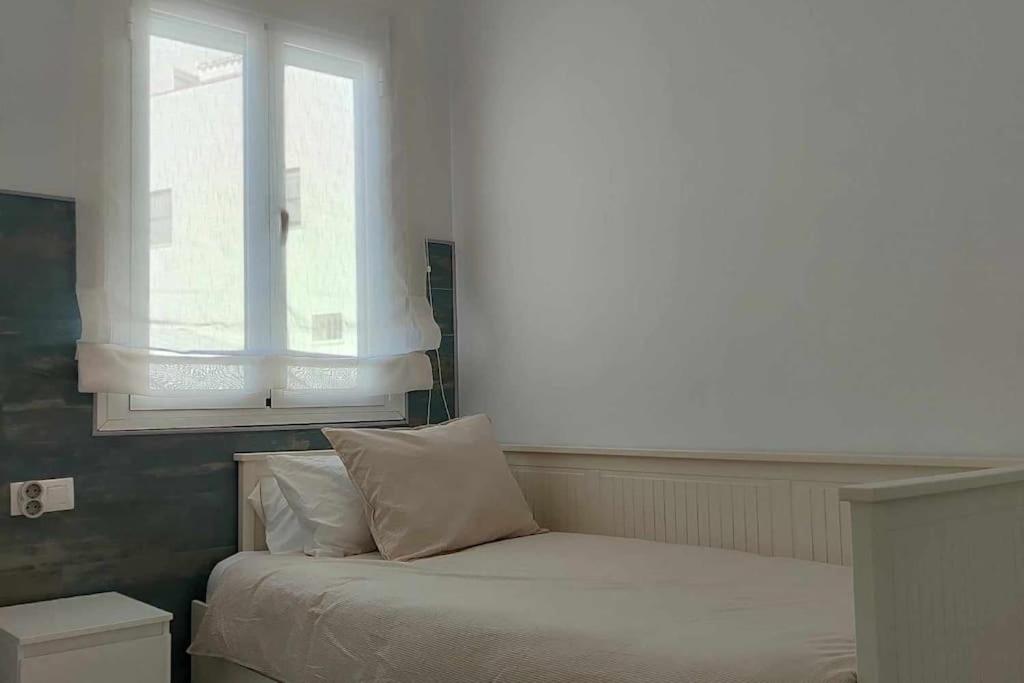 a bed in a room with a window and a bed sidx sidx sidx at Casa Mirador del Puente in Arcos de la Frontera