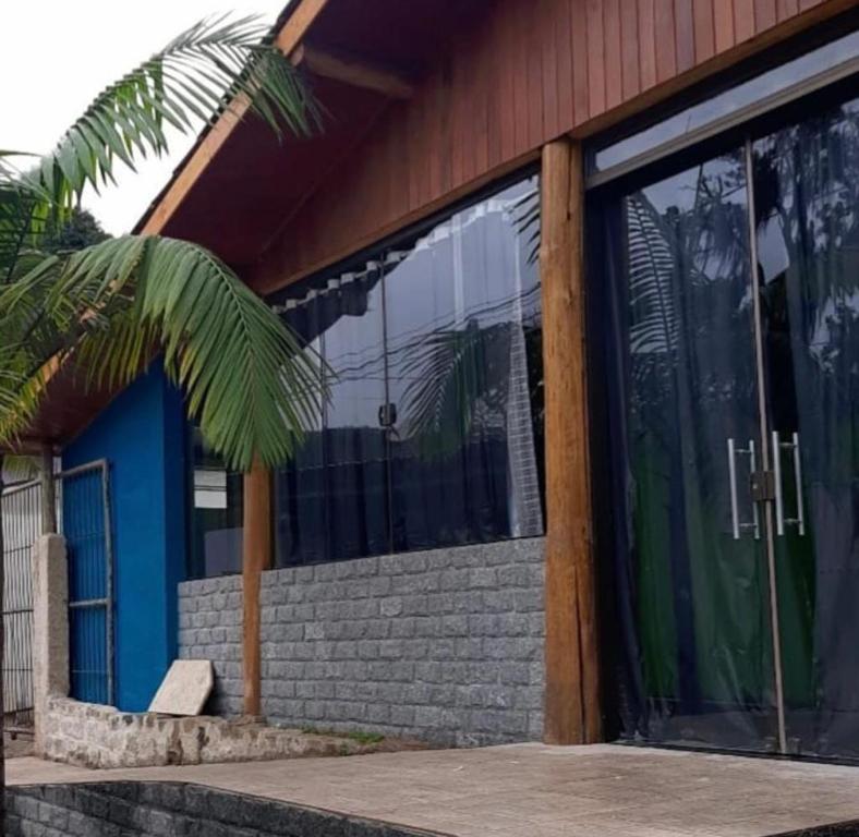 una casa con una puerta azul y una palmera en Casa da Pedra en Aracê