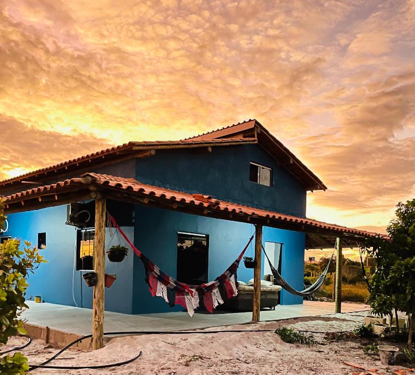 ein blaues Haus mit einer Flagge darauf in der Unterkunft Hostel Caraivando in Caraíva