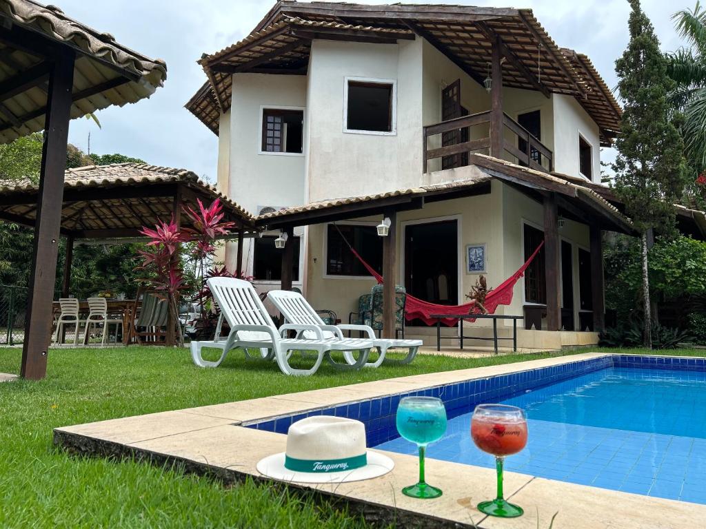 una casa con piscina y dos copas de vino en Casa Bege - Gaia aluguel temporada Mcz, en Maceió