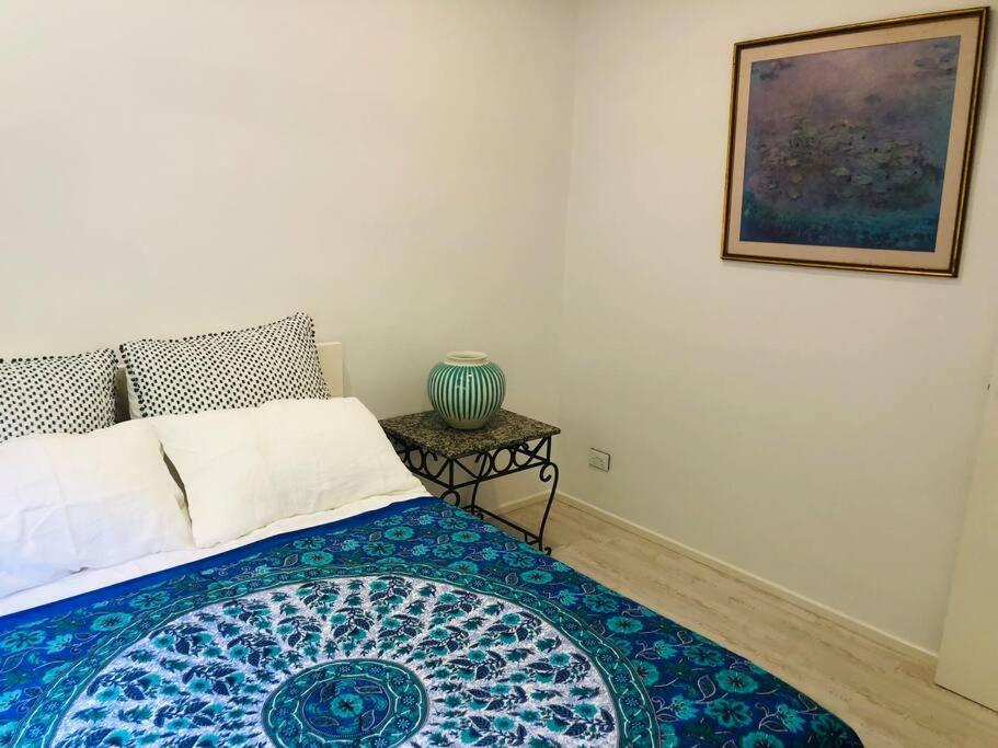 1 dormitorio con 1 cama y un jarrón sobre una mesa en Trinity Beach Oasis en Trinity Beach