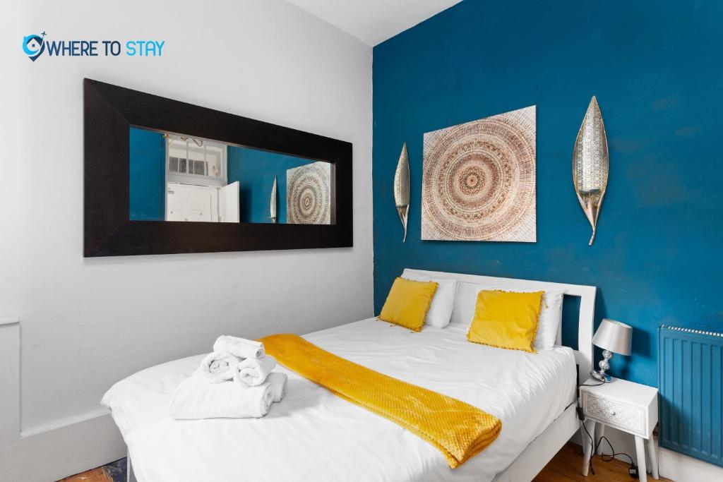 a bedroom with a bed with yellow and blue walls at Tranquil 2 bed apartment Edinburgh in Edinburgh