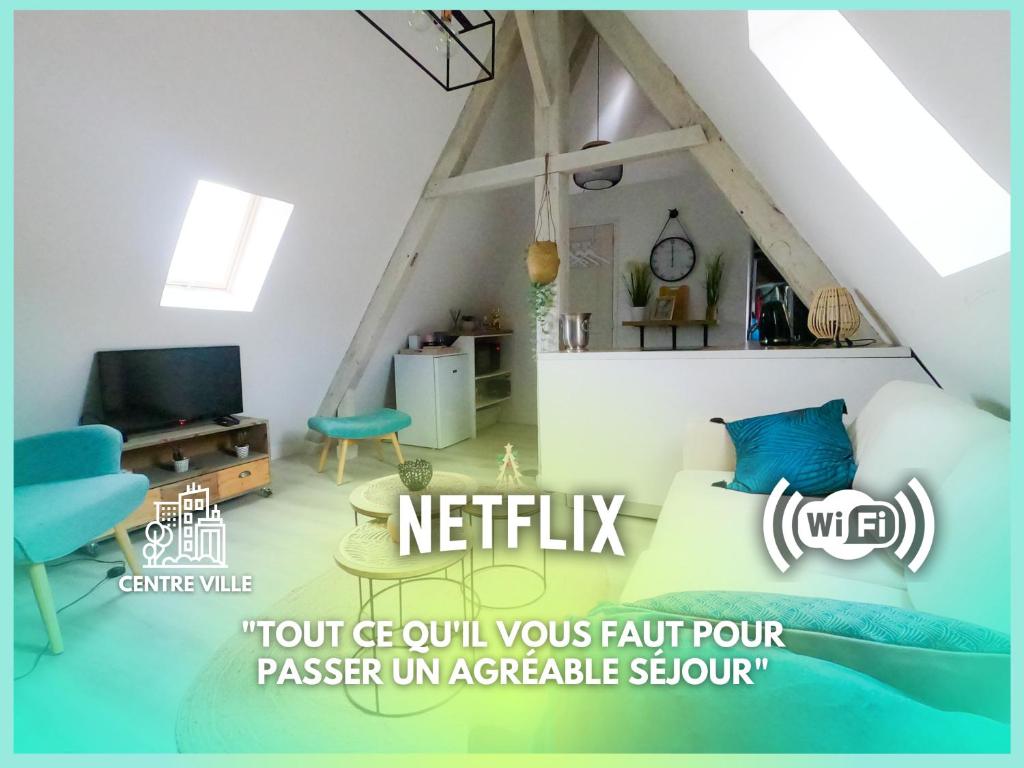 een zolderkamer met een bed en een televisie bij 04 Le Pied-à-terre by Fannny S in Saint-Quentin