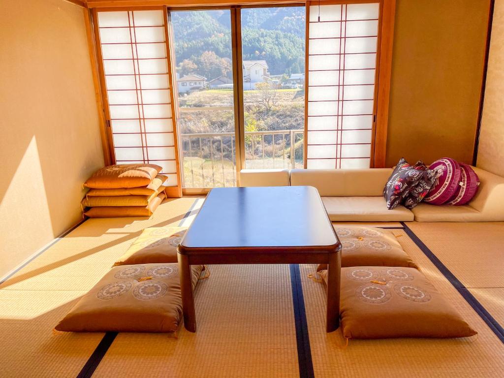 sala de estar con mesa de centro frente a una ventana en 【MeTeL】窓辺から壮大な富士が拝める。リノベーション済み一等貸し宿泊施設 en Nishikatsuracho