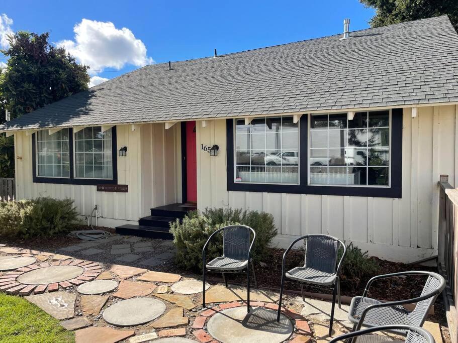 a house with three chairs in front of it at Den Street Cottage in Los Alamos