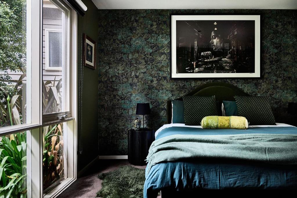 a bedroom with a bed with a picture on the wall at Boatshed Villa Green Door in Daylesford