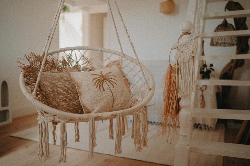 a hanging chair with a pillow in a room at Ti Studio Bohème, avec citerne in Le Gosier