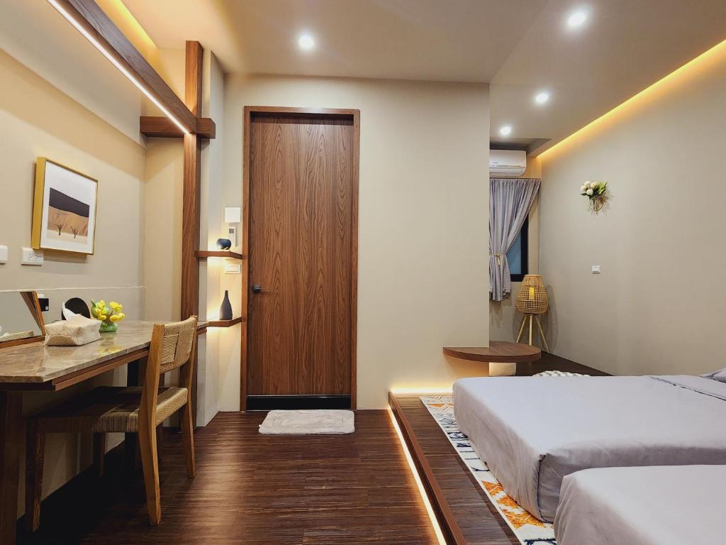 1 dormitorio con cama, escritorio y mesa en Ran has to get up, en Tainan