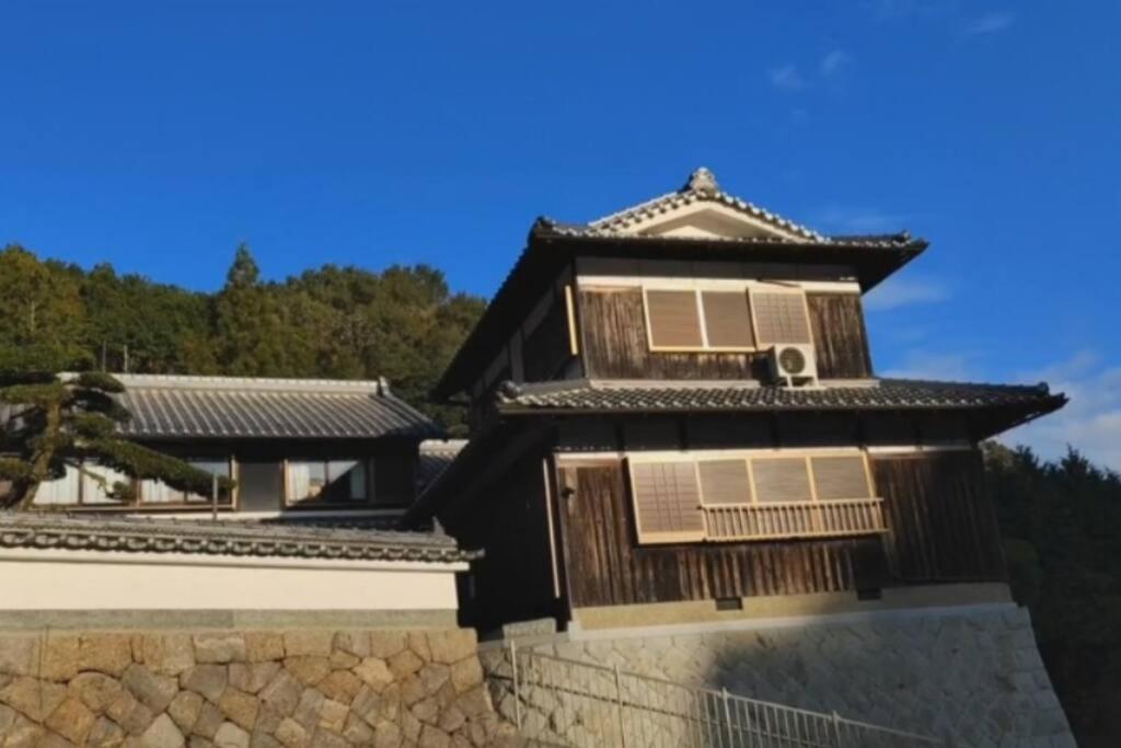 una casa asiática con una pared de piedra en 【1棟貸切】奈良公園から車で約12分　近隣ゴルフ場迄車で約8分　送迎車有り, 