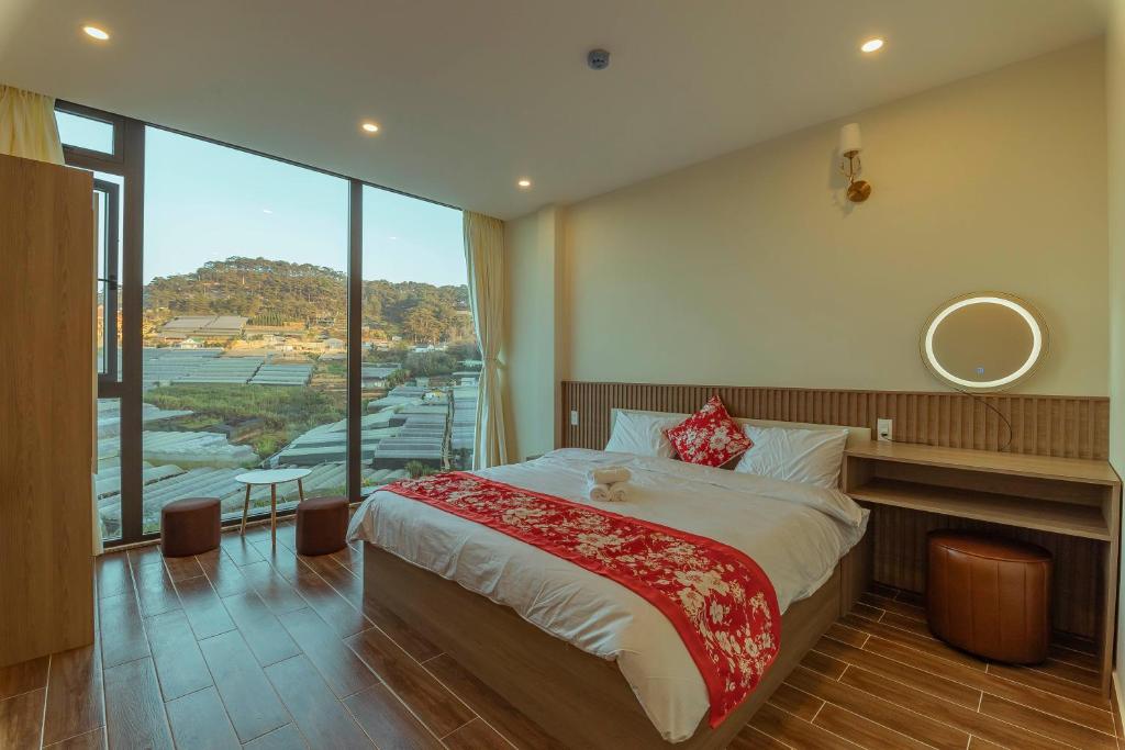 a bedroom with a large bed and a large window at Hoàng Hiệp Villa in Da Lat