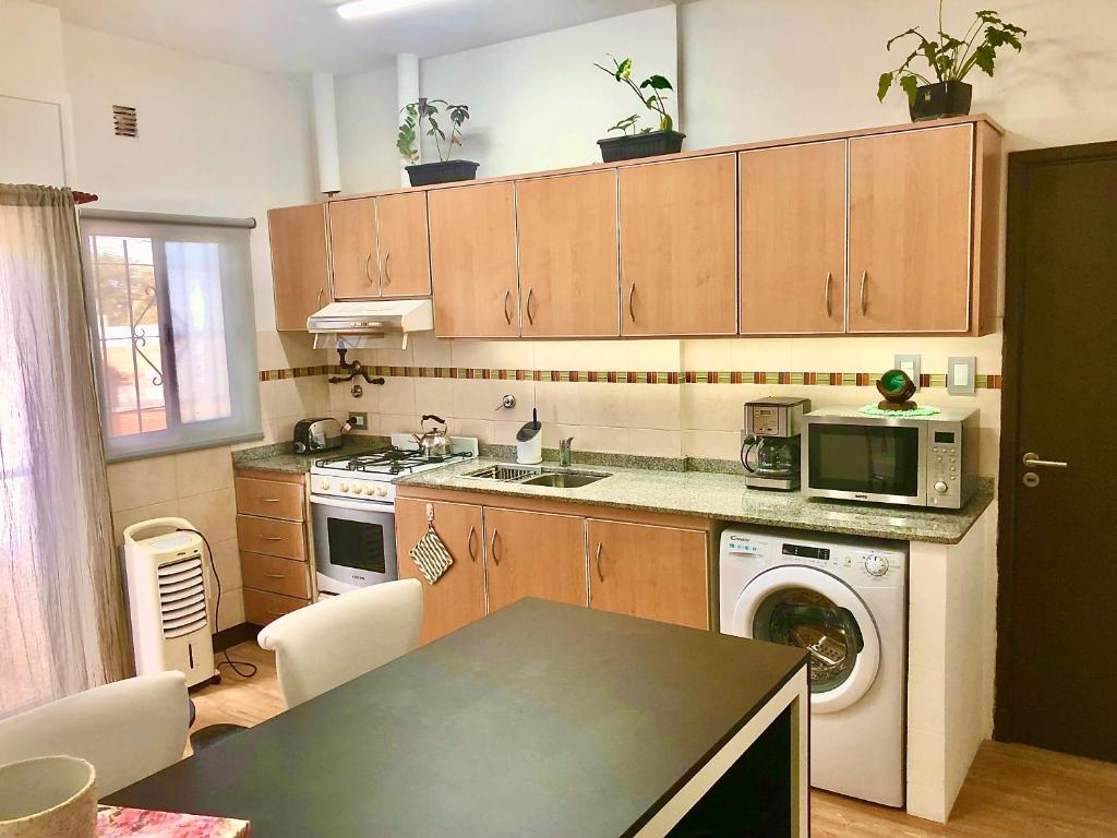uma cozinha com um lavatório, um fogão e um micro-ondas em Alquiler por dia "Como en Casa" Caseros, cerca de Palomar y Hurlingham em Caseros