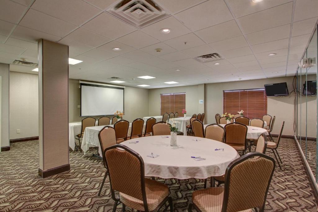 a conference room with tables and chairs and a screen at Holiday Inn Express Savannah South I-95 Richmond Hill, an IHG Hotel in Richmond Hill