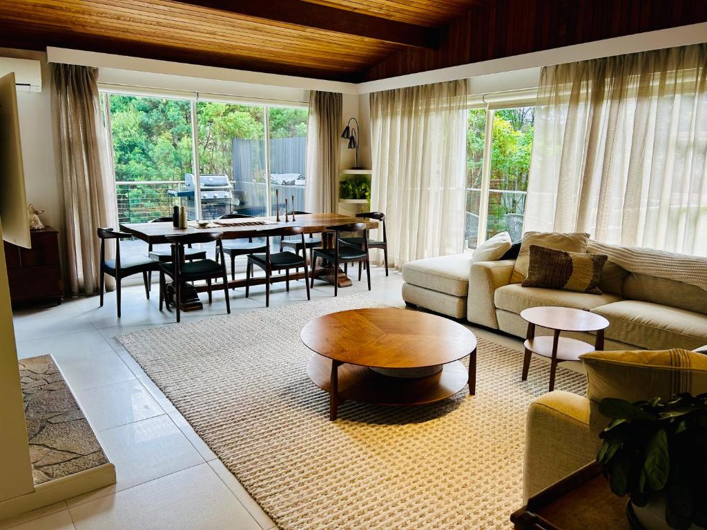 a living room with a couch and a table and chairs at Sandy Bay Haven in Sandy Bay