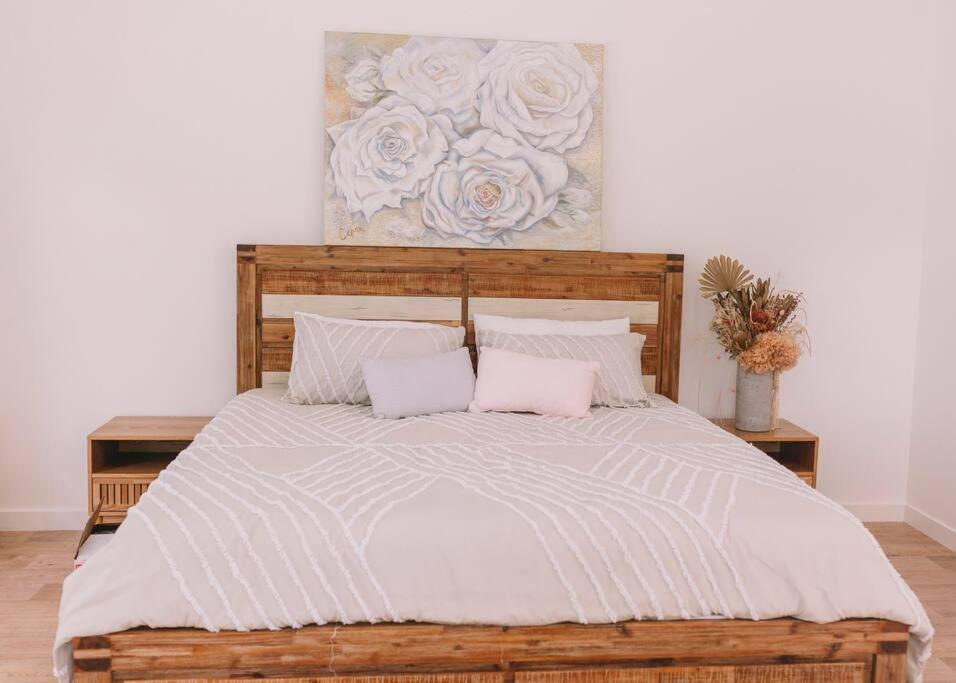 a bedroom with a large bed with two pillows at TreeTops Tamborine Mountain in Mount Tamborine