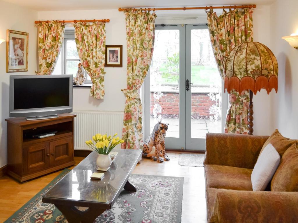 sala de estar con sofá y TV en Daisy Cottage - Uk46262, en Tetney