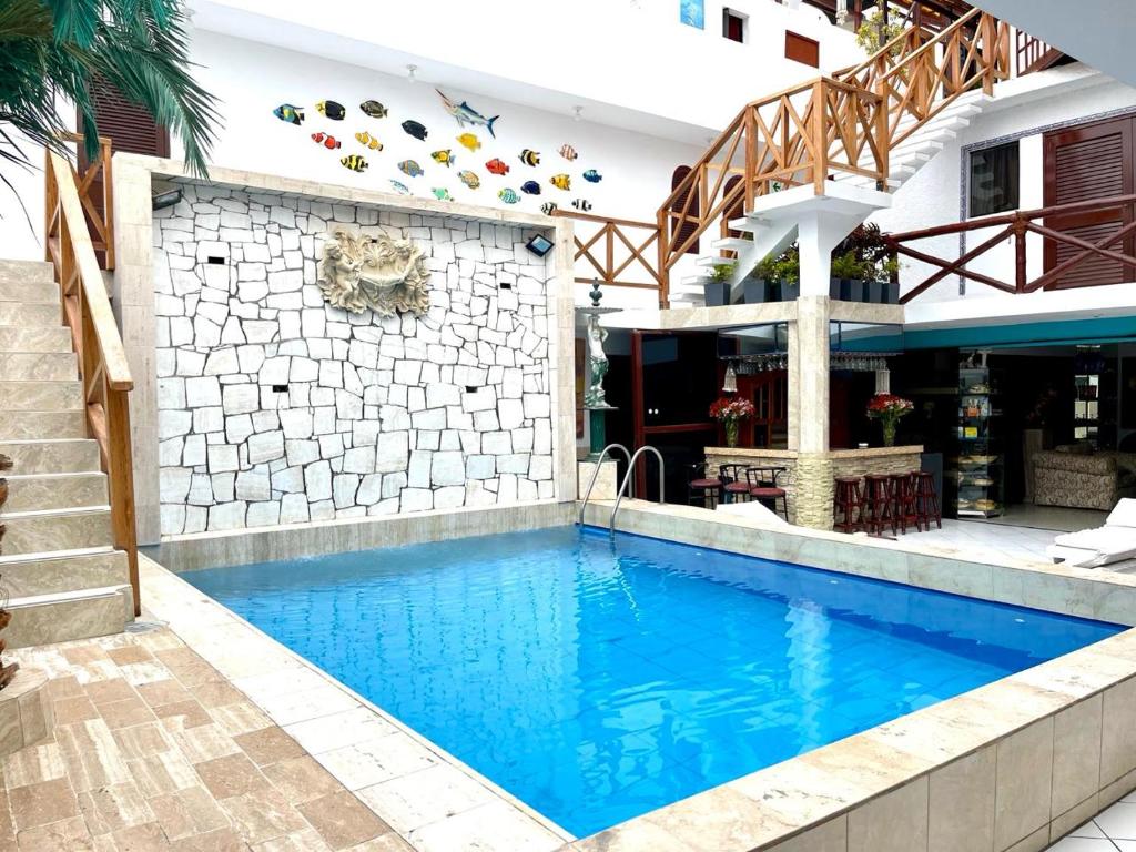 een zwembad voor een huis met een gebouw bij Hostal Ocean Pacifico in Punta Negra