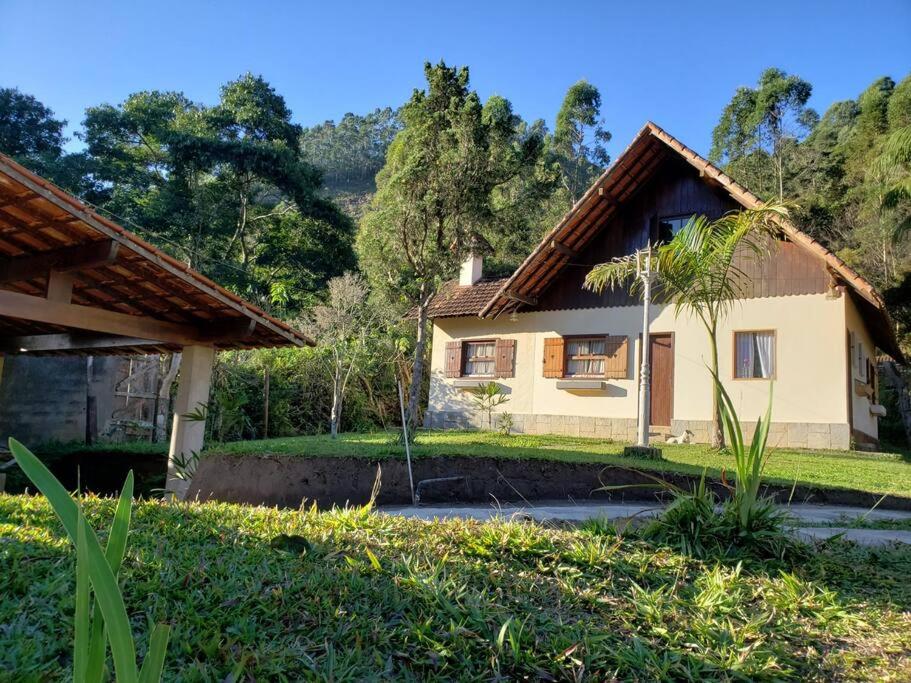 a house with a palm tree in front of it at Casa Chalé Caminho do Vale LEIA O PERFIL in Nova Friburgo