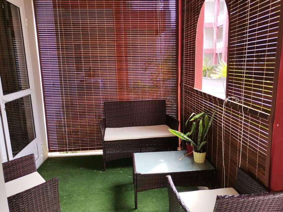 a balcony with a chair and a table and a window at Red Lory residences apartment G1 in Pereybere