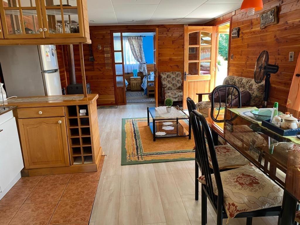 cocina y sala de estar con mesa en Casa acogedora en hermoso entorno Chiloe, en Rauco