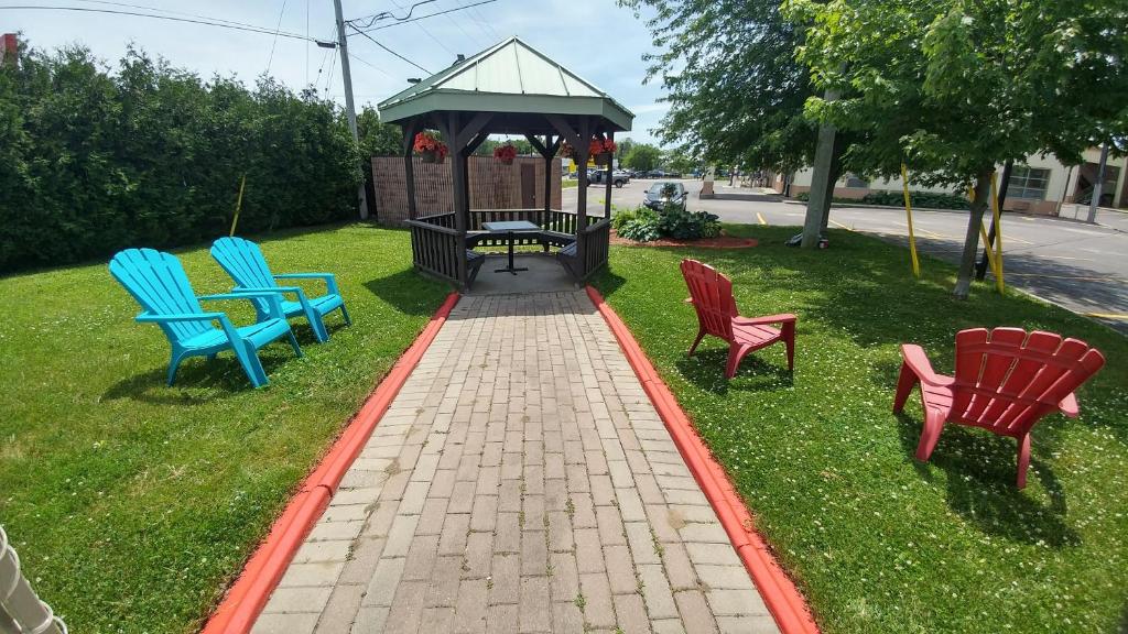 four chairs and a table in a park with a gazebo at Riviera Inn And Suites 1000 Islands in Gananoque