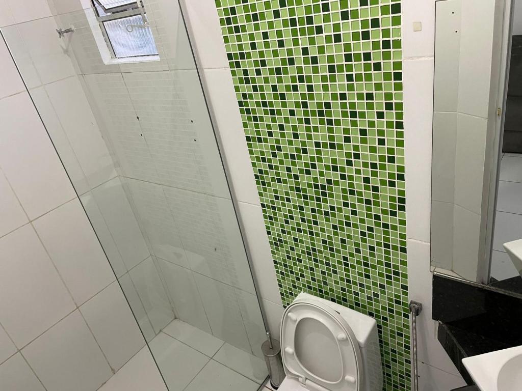 ein Badezimmer mit einem WC und einer grün gefliesten Wand in der Unterkunft Apartamento mobiliado em Barreirinhas MA in Barreirinhas