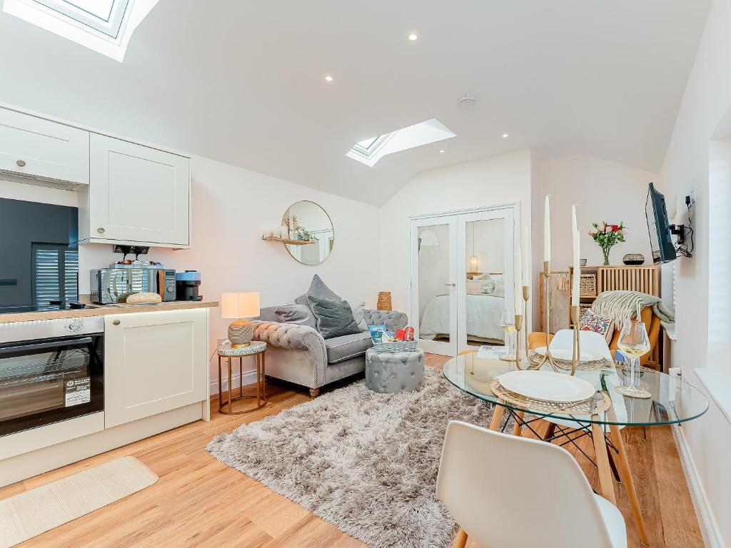 a kitchen and living room with a glass table at The Hideaway in Great Meols