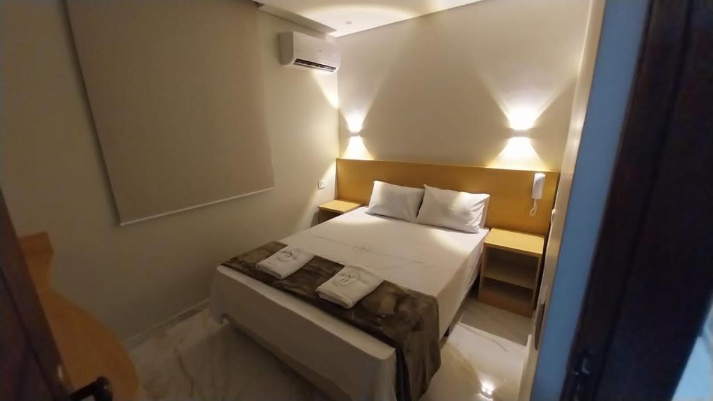 1 dormitorio pequeño con 1 cama con 2 almohadas en Hotel New Space en São Paulo