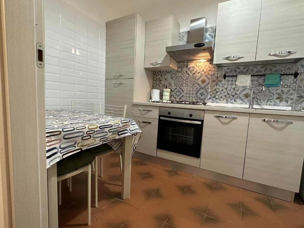 a kitchen with white cabinets and a table in it at fabio rooms 102 in Rome